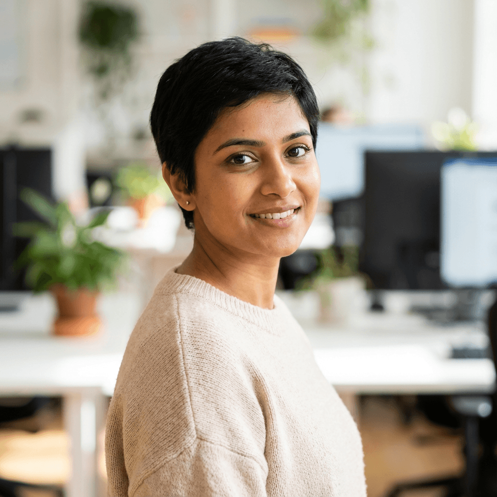 Female cybersecurity analyst in her late 20s working in a bright office